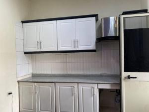uma cozinha com armários brancos e um micro-ondas em Stylish & Convenient Condo for couples and familes em Addis Ababa