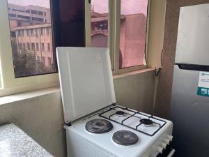 a stove top oven sitting next to a window at Stylish & Convenient Condo for couples and familes in Addis Ababa