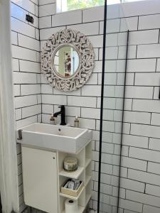 a white bathroom with a sink and a mirror at Downtown Nassau Oasis Unit 2 in Nassau