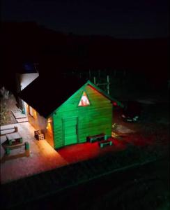 a small green house with a light on it at night at Chico Cabanas in Lajeado Grande