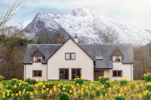a house in front of a snow covered mountain at Woodlands House in Ballachulish
