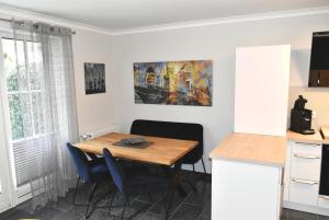 - une salle à manger avec une table et des chaises en bois dans l'établissement Ostseeallee 4 Ferienwohnung Nr 01, à Niendorf