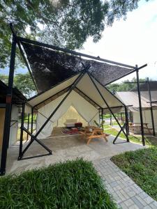 a large white tent with a picnic table inside at Glamping at Xscape Tambun in Tambun