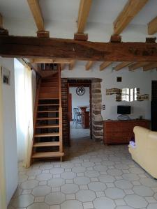ein Wohnzimmer mit einer Treppe und einem Tisch in der Unterkunft Maison Champêtre Huez in Faux-Villecerf