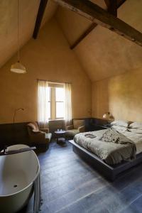 ein Schlafzimmer mit einem Bett und einer Badewanne in einem Zimmer in der Unterkunft The Penny Bun in Otley