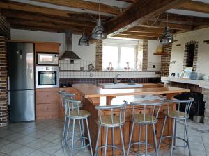 eine Küche mit einer Holztheke und Barhockern in der Unterkunft Maison Champêtre Huez in Faux-Villecerf