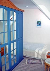 Un dormitorio con una puerta azul y una cama en Ostfrieslandtraum-mit-Kamin-und-Wintergarten en Dornumersiel
