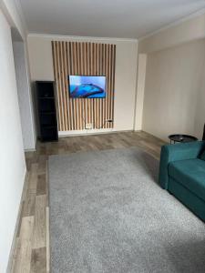 Il comprend un salon doté d'un canapé et d'une télévision à écran plat. dans l'établissement Apartment on Protozanova 21, à Öskemen