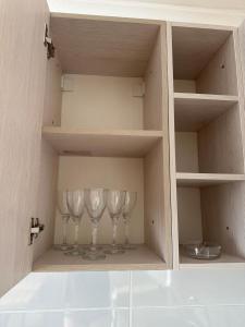 un placard avec trois verres à vin dans l'établissement Apartment on Protozanova 21, à Öskemen