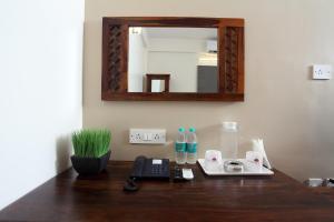 a desk with a mirror and a phone on it at Hotel Crimson Lotus in Bangalore