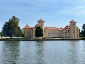 a large building next to a body of water at Haus Hyggelig direkt am Großen Zechliner See in Rheinsberg