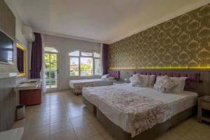 a bedroom with a large bed and a couch at Lykia Botanika Beach Fun & Club - All Inclusive in Fethiye