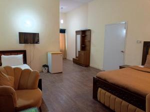 Una habitación de hotel con una cama, un sofá y una silla. en Luxury Moon Guest House, en Islamabad