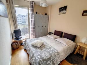 - une chambre avec un lit, une télévision et une fenêtre dans l'établissement Les Thermes d'Evian - Appartement de vacances, à Évian-les-Bains