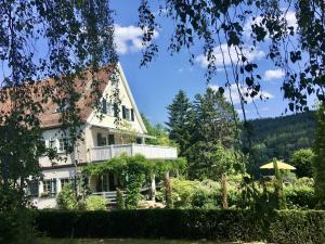 a large white house with a balcony in the yard at Gästehaus Altes Forstamt Sinntal in Sinntal