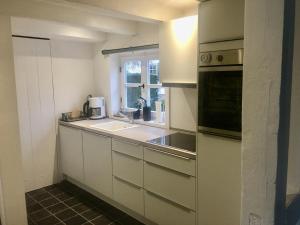 a kitchen with white cabinets and a sink and a window at Gästehaus Altes Forstamt Sinntal in Sinntal +34 photos