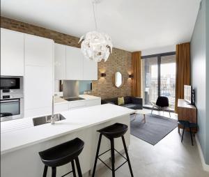 a kitchen with a white counter and stools at Luxury Collection - 2 Bedroom Apartment -Borough Market in London