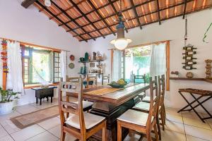 a dining room with a wooden table and chairs at Linda casa em Búzios a 50 m da Praia da Ferradura. in Búzios