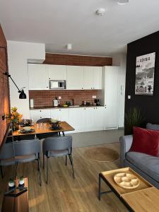 cocina y sala de estar con sofá y mesa en Apartament 215 - Modern Tower Gdynia, en Gdynia