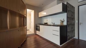 eine Küche mit weißen Schränken und einer schwarzen Arbeitsplatte in der Unterkunft Italianway-Gian Galeazzo in Mailand