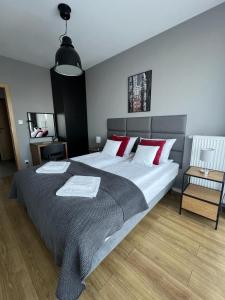 1 dormitorio con 1 cama grande con almohadas rojas en Apartament 215 - Modern Tower Gdynia, en Gdynia