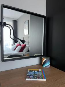 espejo en una habitación con cama y libro en Apartament 215 - Modern Tower Gdynia, en Gdynia