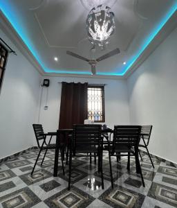 a dining room with a black table and chairs at Lovely 5-Bed House Getaway Duplex in Accra in Accra
