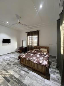 a bedroom with a bed and a television in it at Lovely 5-Bed House Getaway Duplex in Accra in Accra