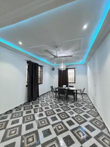 a dining room with a table and a blue light at Lovely 5-Bed House Getaway Duplex in Accra in Accra
