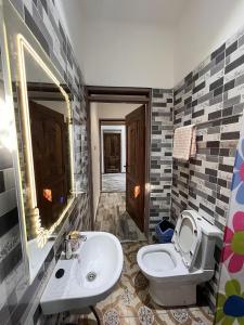 a bathroom with a sink and a toilet at Lovely 5-Bed House Getaway Duplex in Accra in Accra