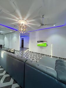 a large room with a couch and a tv on a wall at Lovely 5-Bed House Getaway Duplex in Accra in Accra