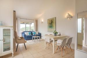 a living room with a table and a blue couch at Appartamento Sea View in Arzachena