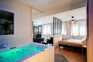 - une chambre avec une baignoire et un lit dans l'établissement Sweet Home Spa, à Achicourt
