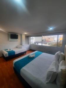 a bedroom with two beds and a large window at Hotel Zafiro Boutique in Bogotá