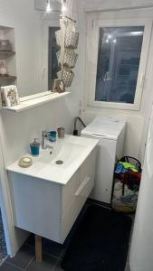Baño blanco con lavabo y espejo en Maison de village avec vue sublime, en Malaussène