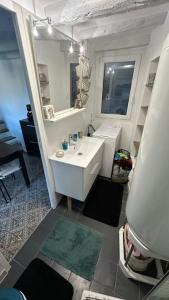 La salle de bains est pourvue d'un lavabo blanc et d'un miroir. dans l'établissement Maison de village avec vue sublime, à Malaussène