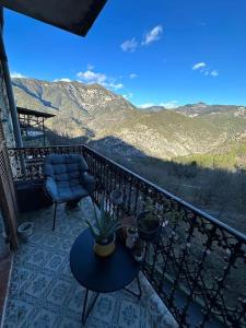 balcón con mesa, silla y montañas en Maison de village avec vue sublime, en Malaussène
