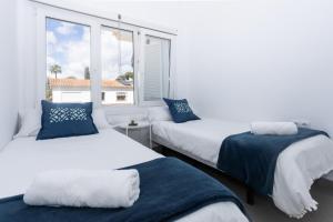 two beds in a room with a window at San Miguel 34 Rooms in Málaga