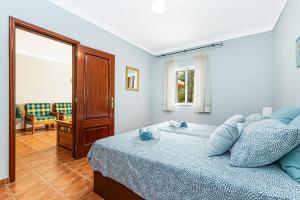 Un dormitorio con una cama con almohadas azules. en Cantinho do Moinho, en Porches 18 fotos más
