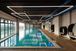 a large swimming pool with blue water in a building at Contemporary apartment at Lemac in Nairobi