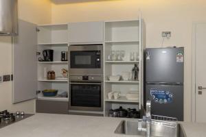 a kitchen with a refrigerator and a sink in it at Contemporary apartment at Lemac in Nairobi