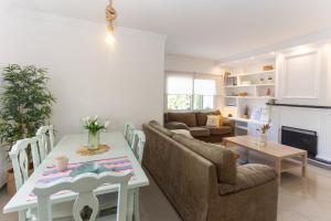 a kitchen and living room with a table and chairs at San Miguel 34 Rooms in Málaga
