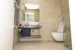 a bathroom with a sink and a toilet and a mirror at Contemporary apartment at Lemac in Nairobi