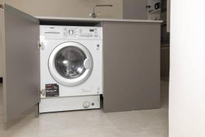 a washing machine sitting under a counter in a kitchen at Contemporary apartment at Lemac in Nairobi