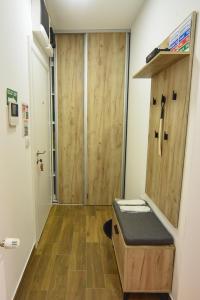 ein Bad mit einer Holztür in einem Zimmer in der Unterkunft BAGDALA RESIDENCE APARTMAN in Kruševac