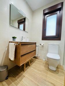 a bathroom with a toilet and a sink and a mirror at Las Casitas de Cueva in Cueva