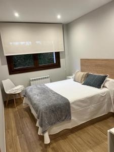 a bedroom with a large white bed and a window at Las Casitas de Cueva in Cueva