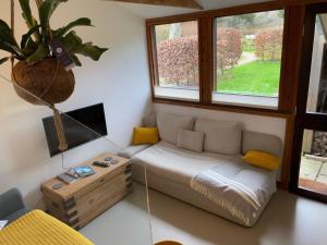 una pequeña sala de estar con sofá y mesa. en A Unique, Rural, Modern Annexe with Large Garden, Games, Tennis Court & EV Point en Chichester