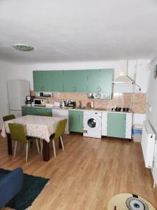 una cocina con armarios verdes y una mesa con sillas en Smile apartments, en Sighişoara