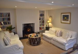 sala de estar con 2 sofás blancos y chimenea en West Pallant Georgian Townhouse in City Centre with Courtyards, BBQ & Log Burners - Dogs Welcome! - Chichester Holiday Properties en Chichester